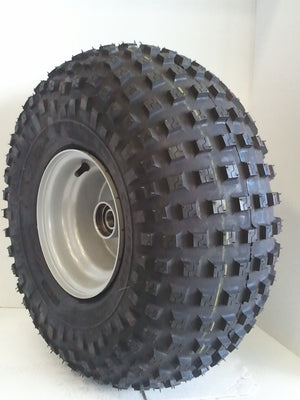A black all-terrain tire mounted on a silver metal rim, photographed against a plain white background.